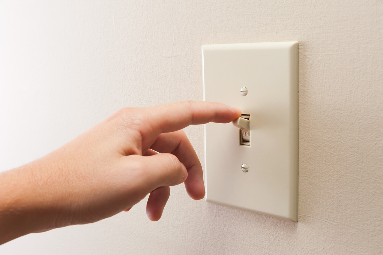 Hand shutting off light switch